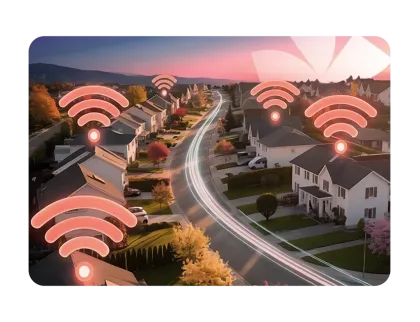 Sunset neighborhood with glowing Wi-Fi icons over houses and light trails on the road symbolizing connectivity.